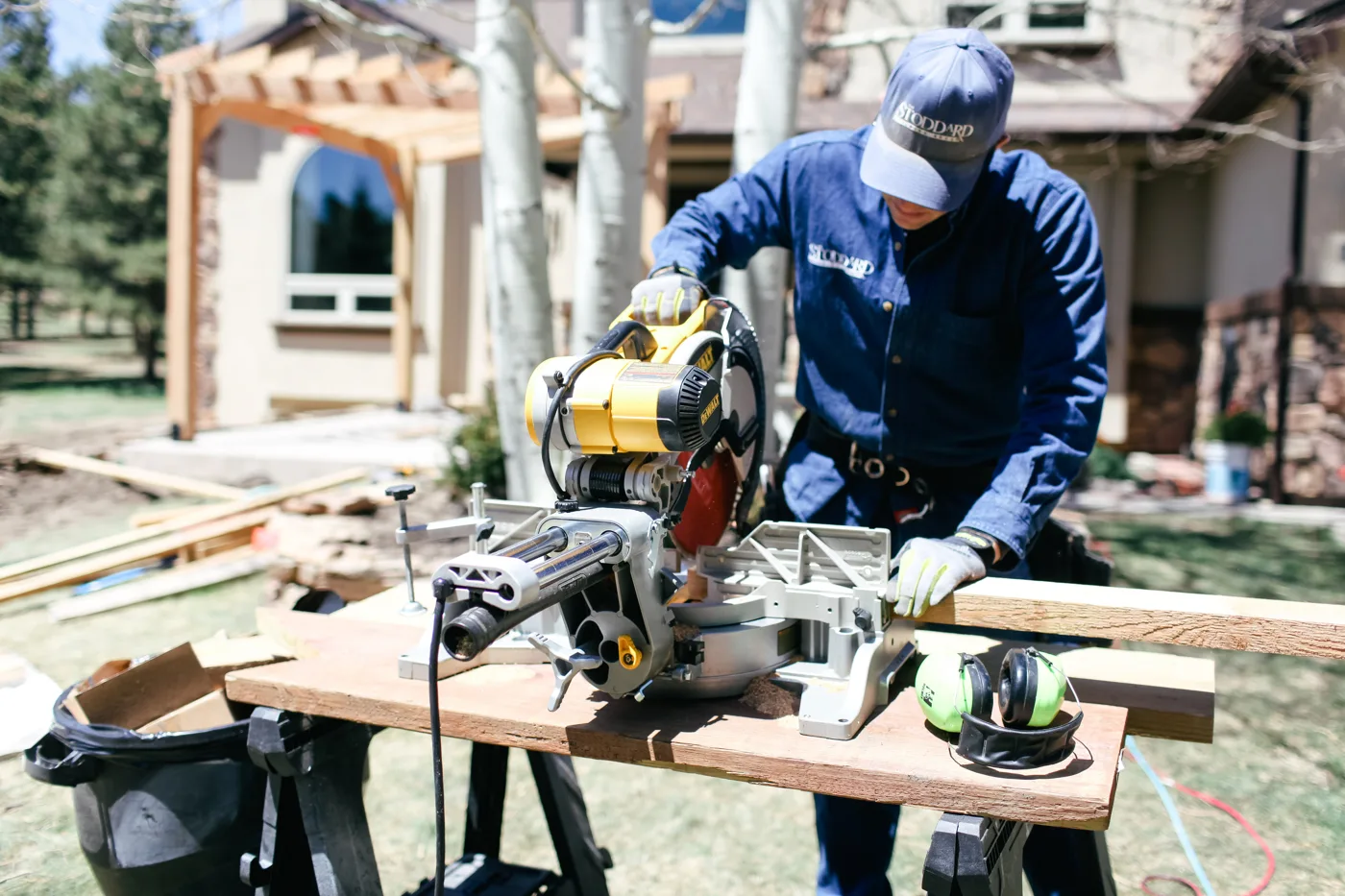Collin Stoddard cutting cedar at the mitre saw on a job site