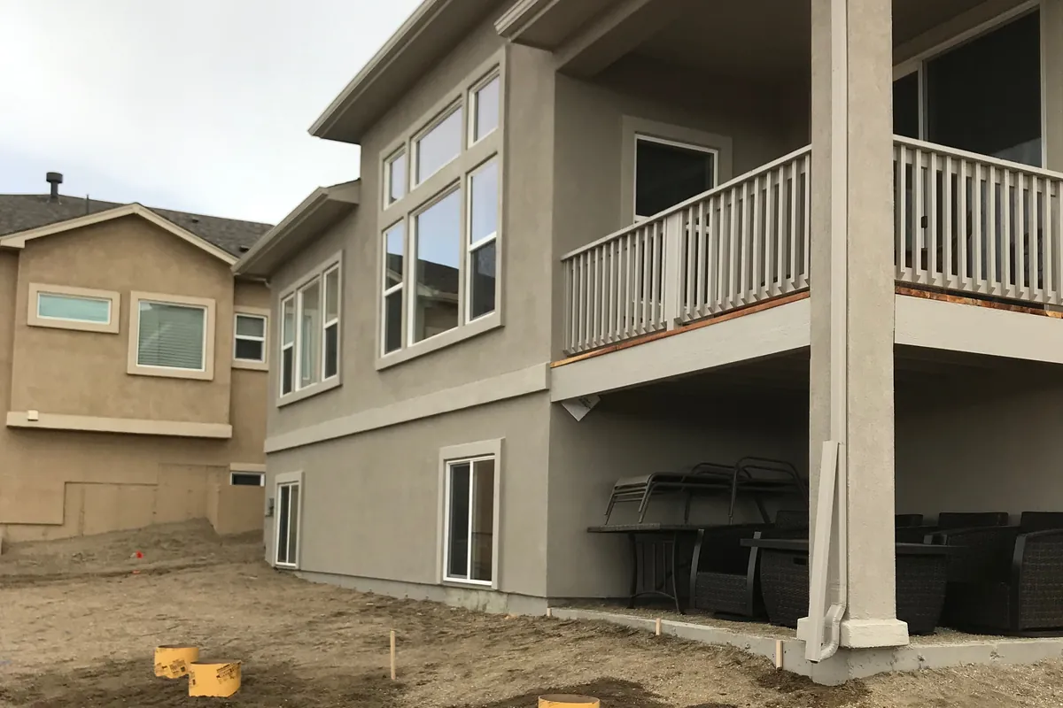 A bare walkout basement and balcony before the work