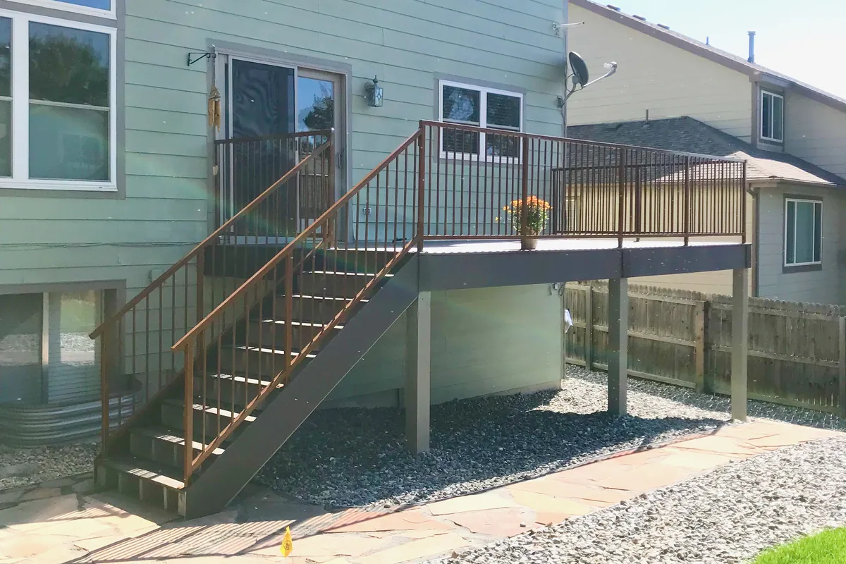 The same deck after, with new composite decking and black steel railing