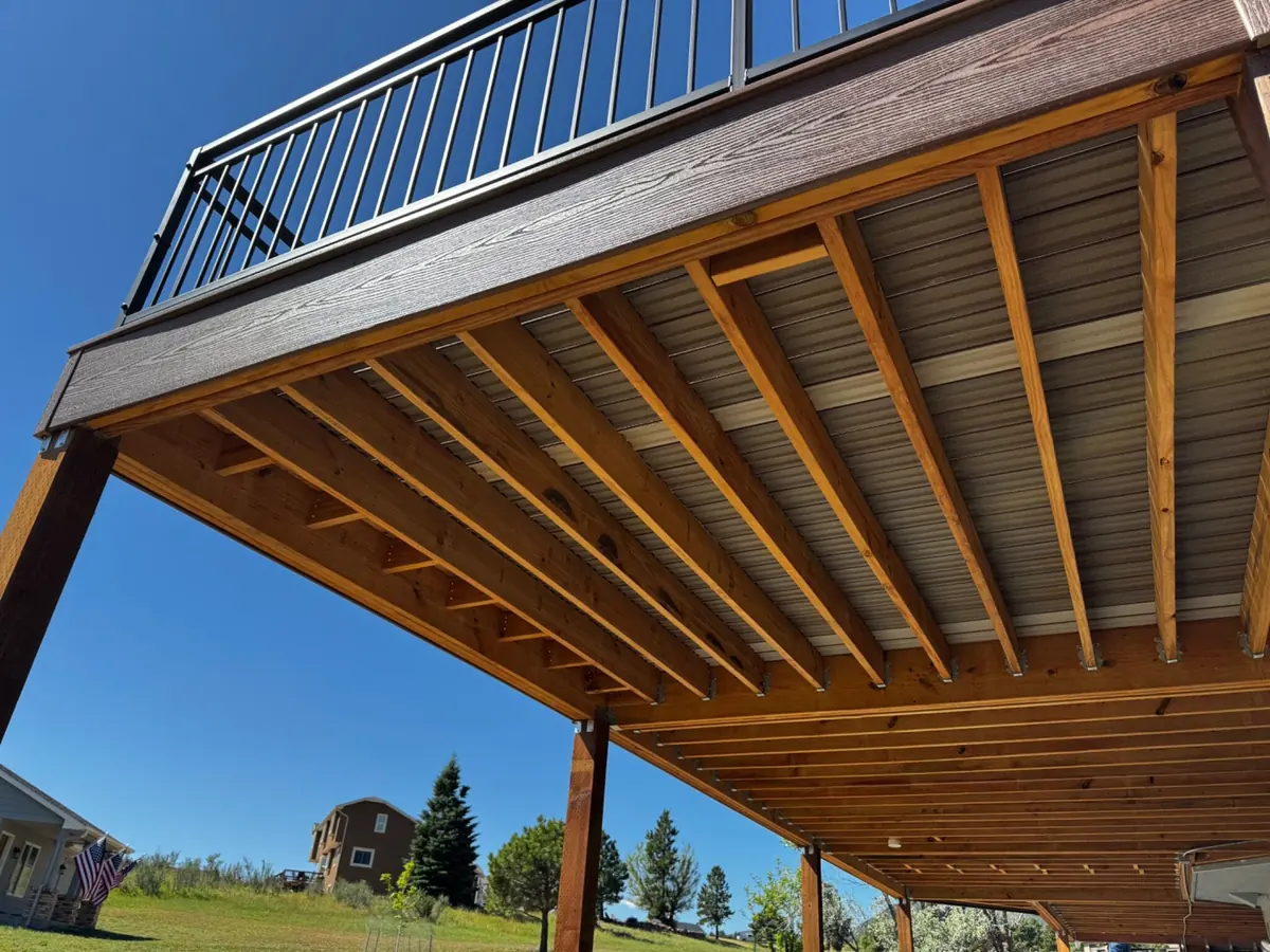 Looking up at the treated wood frame under a raised deck