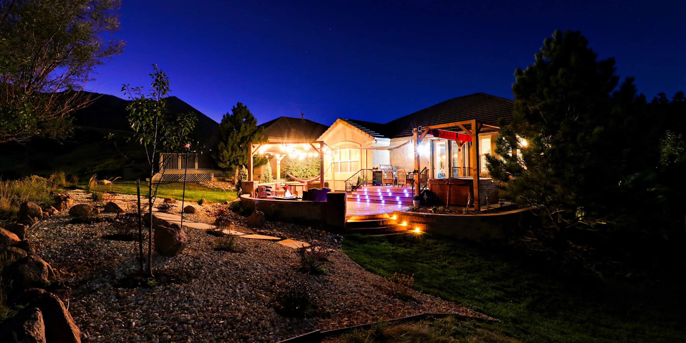 A Stoddard project lit at dusk, seen across the garden