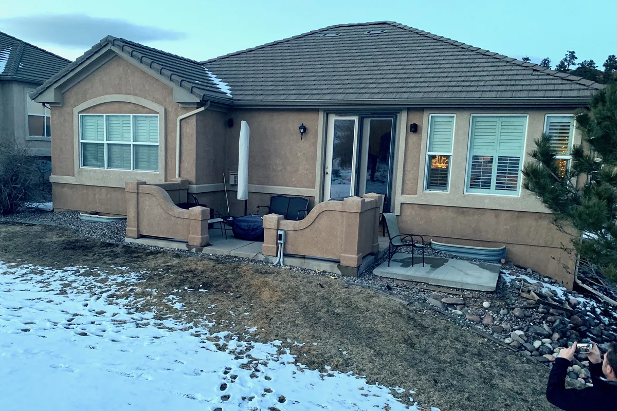 The back of the house before, with a bare patio and no deck